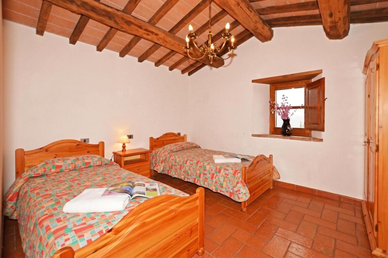 Schlafzimmer mit zwei Einzelbetten und Holzbalkendecke
