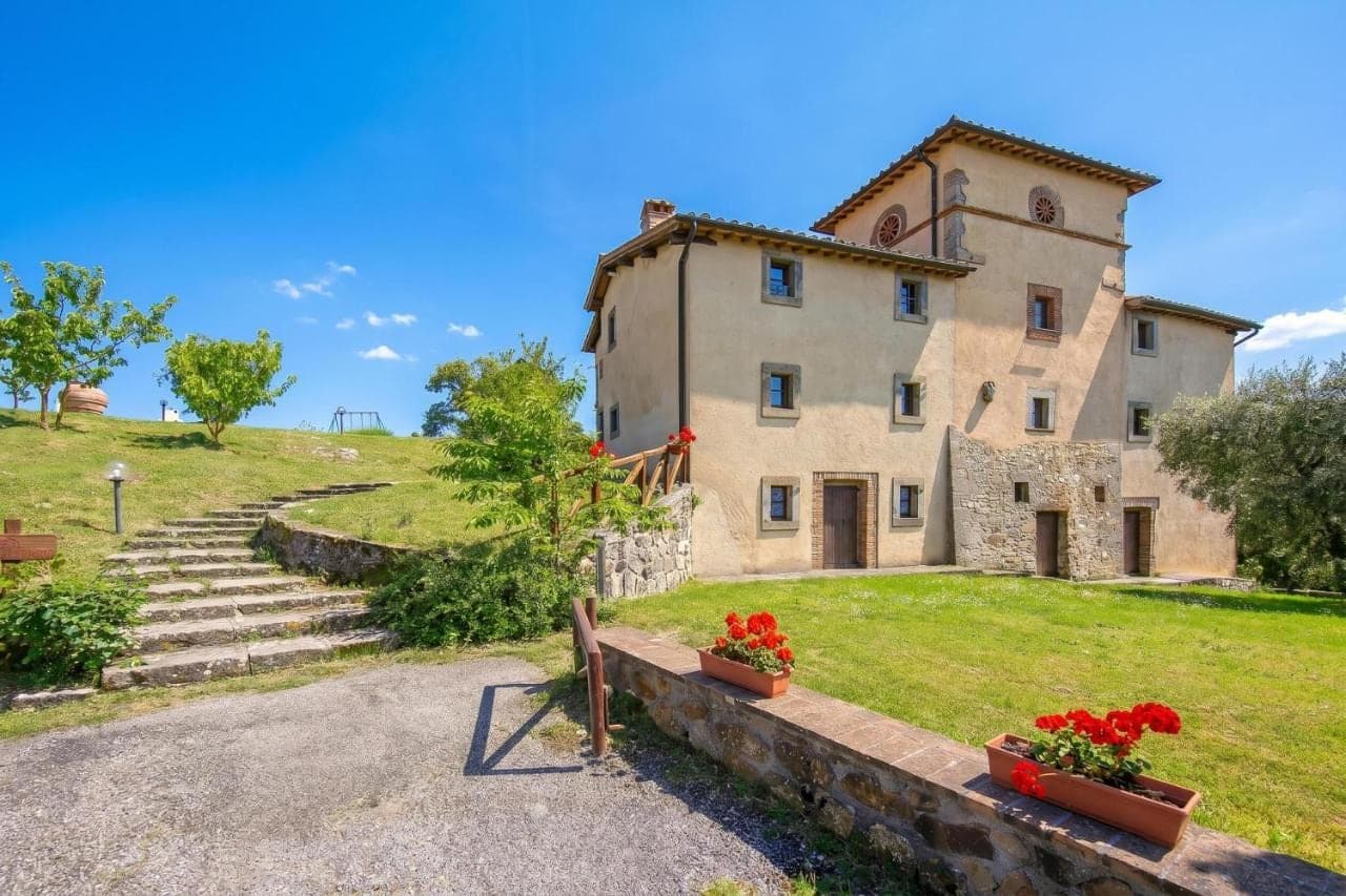 Die Villa La Chiesina mit Steintreppe und Rasen im Frühling